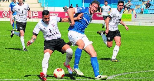 El defensa ecijano Manzano presiona a un rival albaceteño durante el partido. El defensa ecijano Manzano presiona a un rival albaceteño durante el partido.