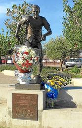 Imagen de los ramos de flores bajo la estatua de Antonio Puerta. Imagen de los ramos de flores bajo la estatua de Antonio Puerta.