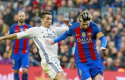 Ronaldo y Messi disputando un balón en el Clásico. Ronaldo y Messi disputando un balón en el Clásico.
