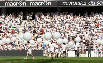 Niños en el terreno de juego portando globos blancos. Niños en el terreno de juego portando globos blancos.