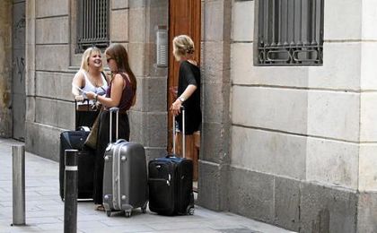 Tres turistas esperan delante de un piso de alquiler en Barcelona. Tres turistas esperan delante de un piso de alquiler en Barcelona.