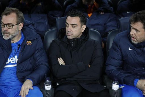 Xavi, sentado en el banquillo del FC Barcelona junto a sus asistentes. 